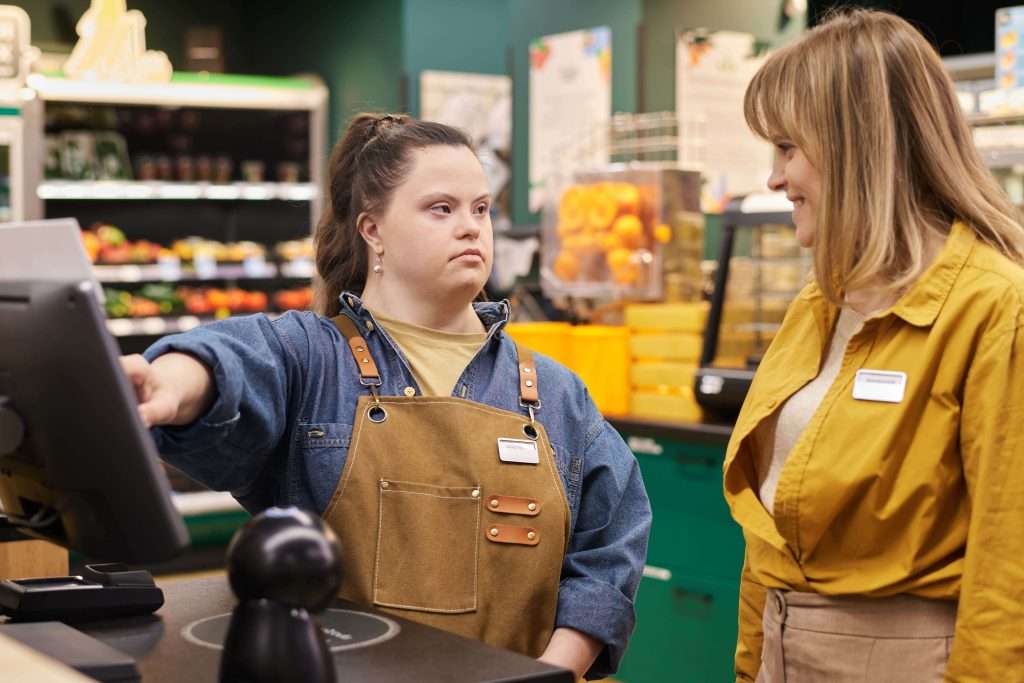 girl-with-disability-working-at-cash-register-in-s-2024-05-22-00-52-35-utc-min